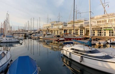 Trieste, İtalya - 16 Şubat 2020: Sacchetta marinası, arka planda tarihi Lanterna feneriyle birlikte bir kış öğleden sonra