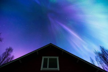 Terk edilmiş eski kulübenin üstündeki Aurora Borealis.