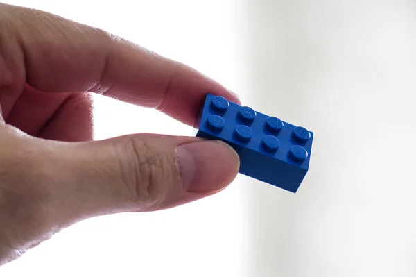 Hand met blauwe Lego baksteen — Stockfoto