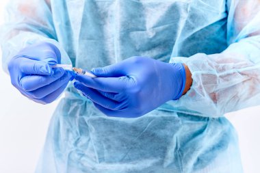 Yakışıklı genç doktor hastane veya klinik bir hastayı tedavi için lastik eldiven koyarak