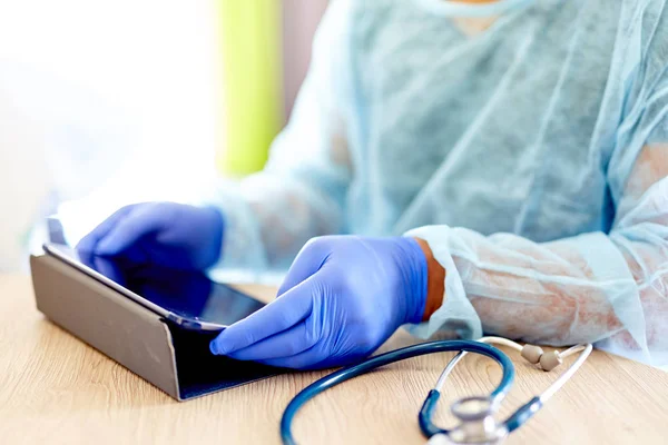 Médico usando tableta con guantes y estetoscopio — Foto de Stock