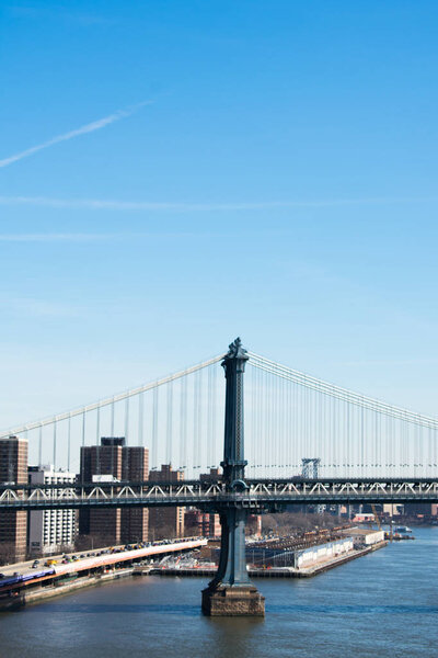 A side view of the Manhattan Bridge, in New York City. It was a sunny day wiht a blue sky.