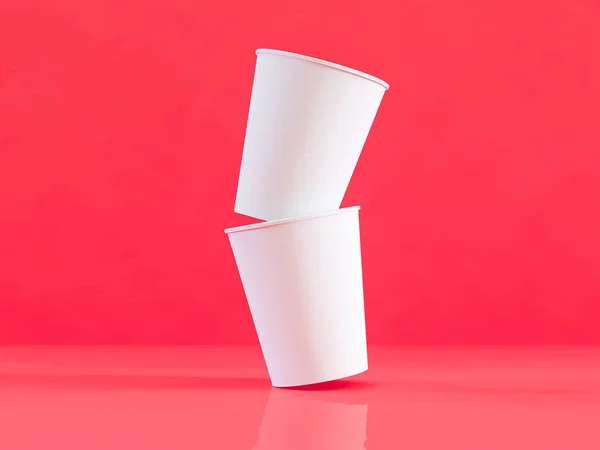 3D модель бумажных стаканчиков на плоскости при естественном освещении. Красный фон. Трехмерный рендерер . — стоковое фото