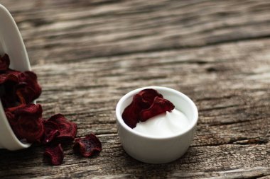 Pancar cipsi. Kullanışlı el yapımı sebze atıştırmalığı. Bir tabakta kök sebze parçaları var. Sarımsak, biberiye ve sos bir tabak içinde. Yumuşak odak