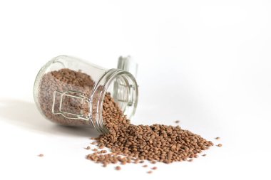 Masanın üzerinde cam bir kavanoz var. Kırmızı mercimek döküldü. Gelecekteki kullanım için yiyecek stokları. Güvenli ve çevre dostu gıda deposu. Uzayın tasarımında minimalizm.