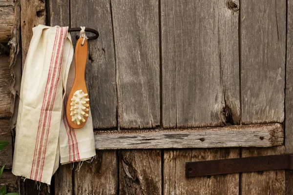 Bath brush on a gray wooden background. Spa pampering in the sauna or bath. Dry body massage.