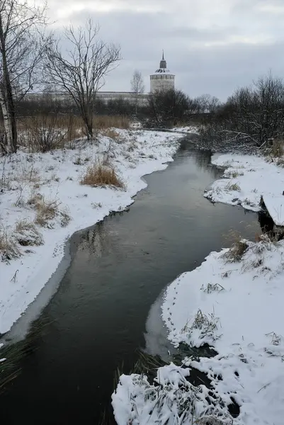 Winterlandschaft. ein kleiner Fluss, ein altes Kloster. — Stockfoto