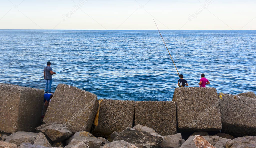 Fisherman sitting on the dock of a port