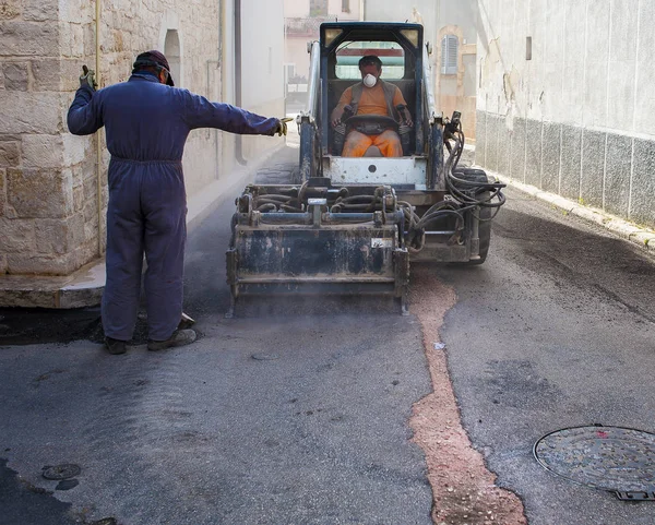 Trabalhador verifica o progresso da Fresagem de asfalto — Fotografia de Stock