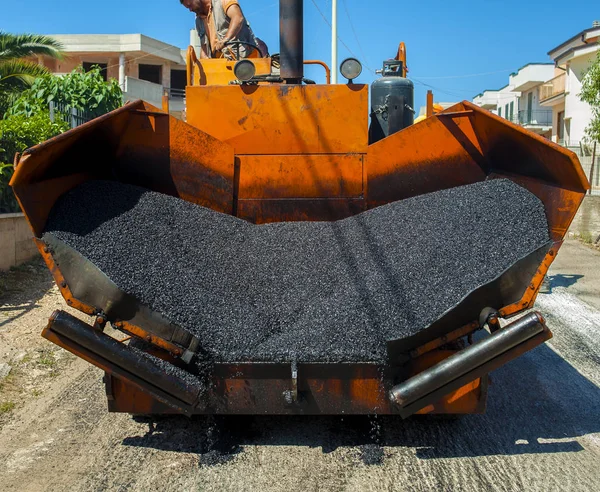 Travailleurs sur une machine de pavage contrôlent la rédaction d'une nouvelle couche d'asphalte — Photo