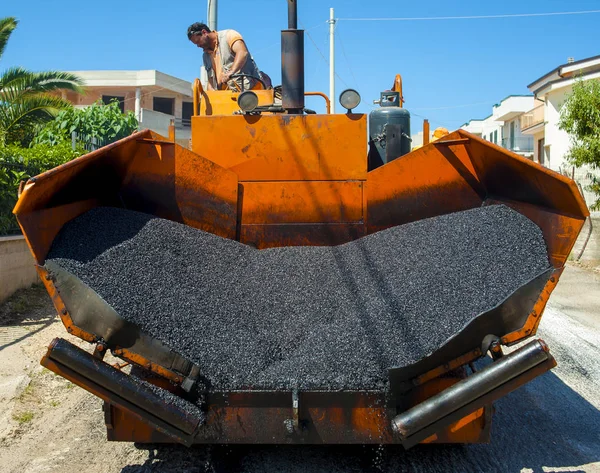 Travailleurs sur une machine de pavage contrôlent la rédaction d'une nouvelle couche d'asphalte — Photo