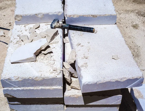 Martillo de construcción, pila de losas de piedra caliza tallada camino pavimento — Foto de Stock