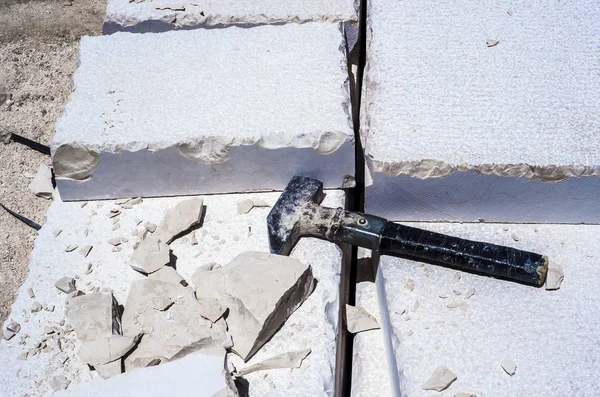 Martelo de construção, pilha de lajes de pedra calcária esculpida estrada pavimento — Fotografia de Stock