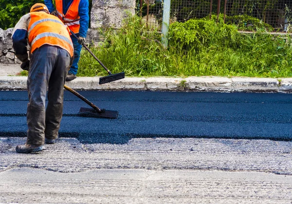 Trabajador en máquina de asfalto pavimentadora — Foto de Stock