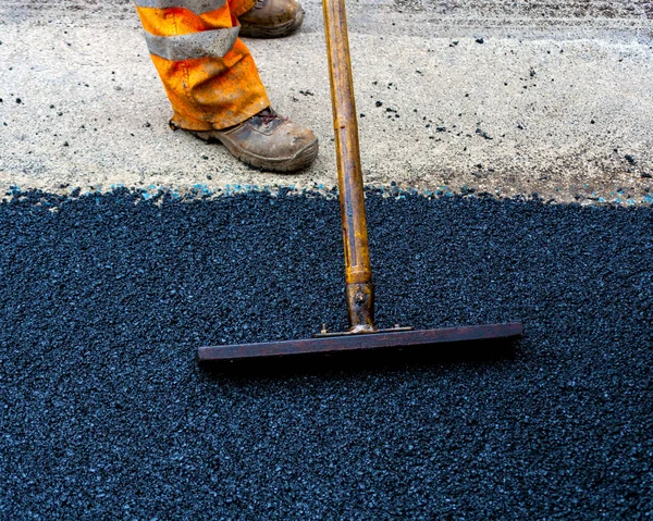 Trabajador en máquina de asfalto pavimentadora — Foto de Stock