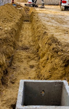 Boru döşeme kazıları sırasında bir yol çalışması için kazıcı