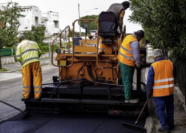Bari, ITALY - 20 Nisan 2016: Road Street onarım çalışmaları sırasında kaldırım makinesini çalıştıran işçiler
