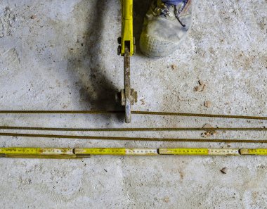 İşçi inşaat alanındaki cıvata kesicilerle takviye ağını kesiyor.