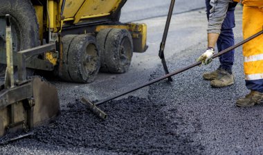 Asfalt paver ile inşaat sırasında 160 derecenin üzerindeki sıcaklıklara ısıtılan. Yol özel ekipman yolu döşeme.