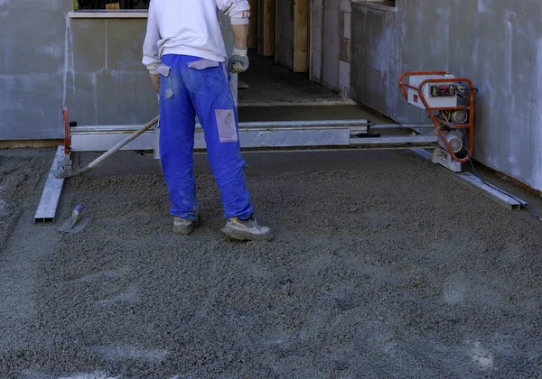 建筑工地用激光螺杆压平新浇注混凝土表面的工人 — 图库照片