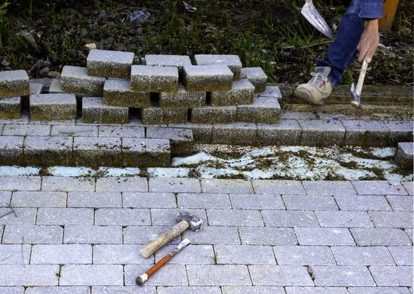 Trabalho de manutenção em pavimentação com pedras de pavimentação entrelaçadas. Indústria de materiais de construção; Produtos de betão para a construção de estradas ou calçadas . — Fotografia de Stock