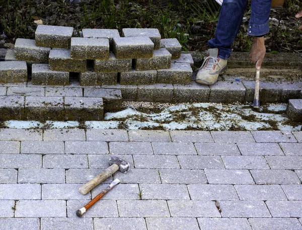 Maintenance work on paving with interlocking paving stones. Building materials industry; Concrete products for road or sidewalk construction. — 스톡 사진
