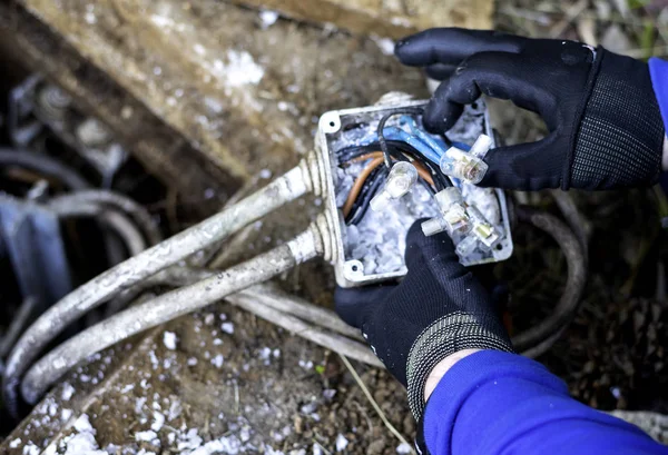Maintenance of a plant wiring box of street lighting. Close-up view of an electrician's hands — Stock Photo, Image