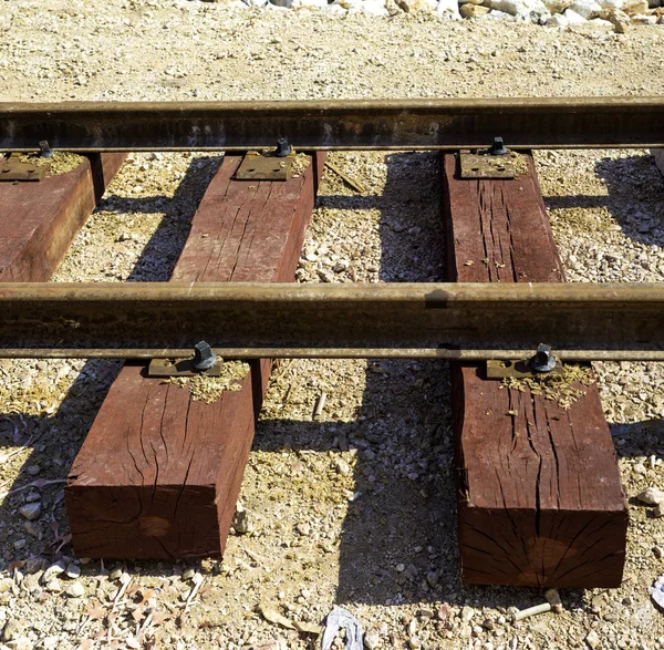 Bolted butt of rails and wooden sleepers laid on groundwork crushed stone. Railway industry and transport infrastructure — Stock Photo, Image