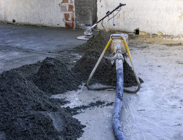 Trabajador en una máquina de solado láser nivelación de superficie de hormigón vertido fresco en un sitio de construcción — Foto de Stock