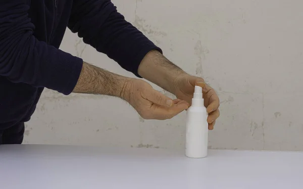Disinfecting hands using antiseptic spray on hands to prevent coronavirus or flu disease.
