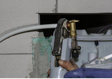 İşçi, bir pistte asfalt döşeyen ve 160 derecenin üzerindeki sıcaklıklara ısıtılan kaldırımları düzenler.