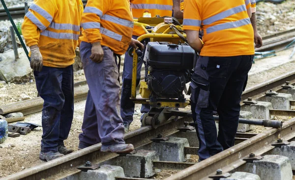 Railway workers bolting track rail. Detail worker with mechanical bolting wrench