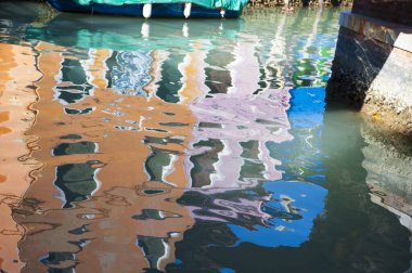 Burano (Venice) karakteristik renkli evlerin bir kanal su üzerinde yansıyan