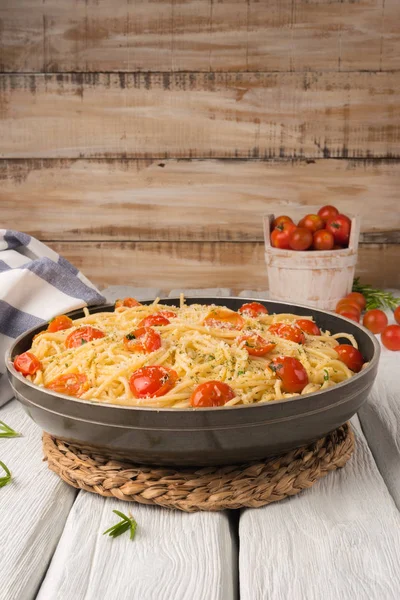 Špagety s rajčaty a petrželkou na dřevěný stůl — Stock fotografie