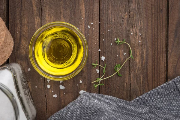 Olive oil with thyme and salt flower on wooden background — Stock Photo, Image
