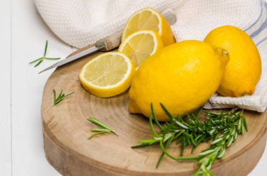 Dilimler, biberiye yaprağı ve bıçak ile yarım taze sulu limon