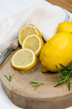 Dilimler, biberiye yaprağı ve bıçak ile yarım taze sulu limon