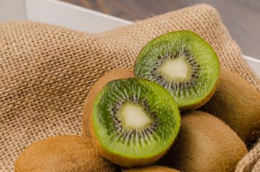 Ahşap arka plan üzerinde içinde taze kivi kutusu.