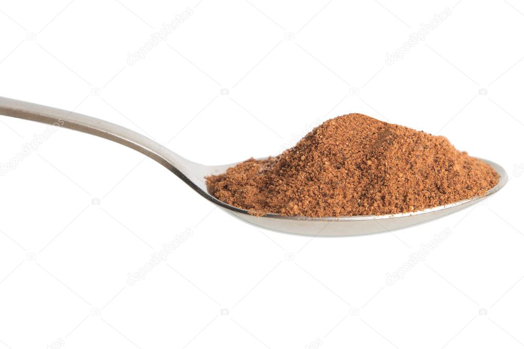 Nutmeg powder in spoon. Isolated in white background.
