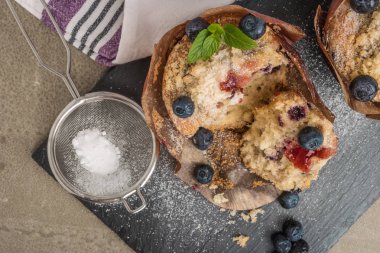 Pudra şekeri ve taze böğürtlenli yabanmersinli kek.