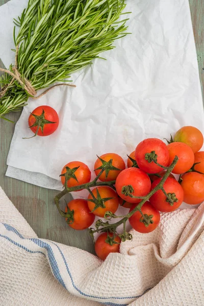 Organic cherry tomatoes with rosemary on wrinkled paper — Stock Photo, Image