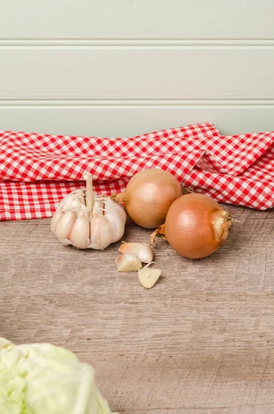 Verse groenten uit de tuin, knoflook en uien op een houten — Stockfoto