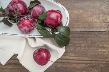 Ahşap arka plan üzerinde lezzetli kırmızı Erik dalı.