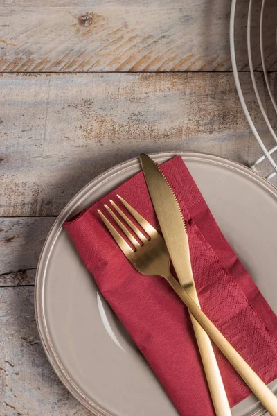 De instelling van de tabel met plaat gouden vork en mes op houten achtergrond. — Stockfoto