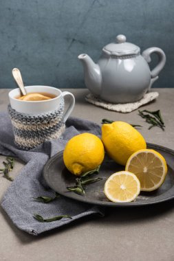 Tablo yakın çekim üzerinde limonlu çay fincan. Sağlık geleneksel tıp ve grip kavramı - limon ile çay bardağı. Sıcak çay limon tedavi soğuk algınlığı grip ve akıntısı ile.