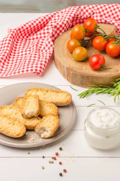 Ekologiska körsbärstomater med rosmarin, svenska rostat bröd och färskost — Stockfoto