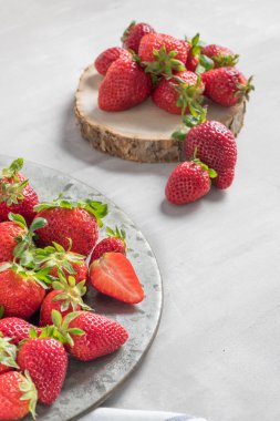 Tabak dolusu çimento zemin üzerine taze çilek. Ham çilek