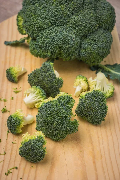Roher Brokkoli auf Holzbrett gehackt. Gesunde Küche — Stockfoto