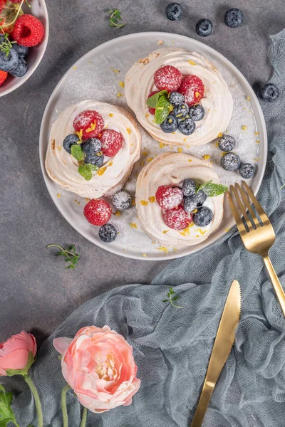 Mini torte di meringa pavlova con lamponi freschi e mirtilli con foglie di menta — Foto Stock