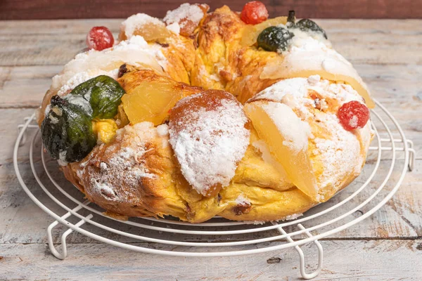 Merry Christmas cake with nuts - Bolo Rei is a traditional Xmas cake with fruits raisins nut and icing on wooden table